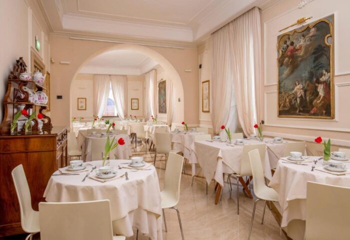 Hotel Canada's dining room. Gay-friendly hotel with tables set for breakfast, white linens, tulips, and antique art. Elegant and inviting space.