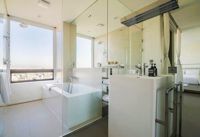 Hotel Cappuccino Seoul's bathroom. Modern design with a tub by the window overlooking the city. Gay-friendly hotel in Seoul, South Korea.
