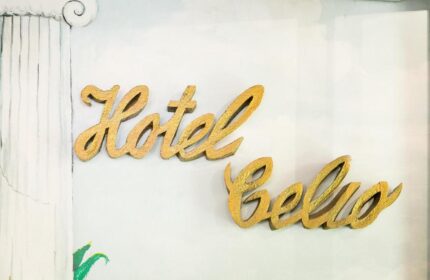 Hotel Celio sign. Gay-friendly Hotel Celio's golden lettering on a white wall with a painted column detail. Gay travel advice.