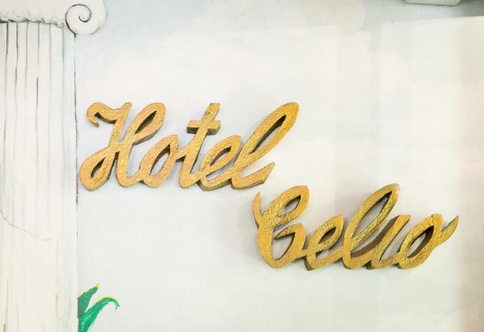 Hotel Celio sign. Gay-friendly Hotel Celio's golden lettering on a white wall with a painted column detail. Gay travel advice.