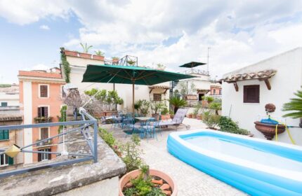 Hotel Celio: Gay-Friendly Hotel rooftop terrace view. Outdoor seating, umbrella, inflatable pool and city views for gay men travelers in Rome.