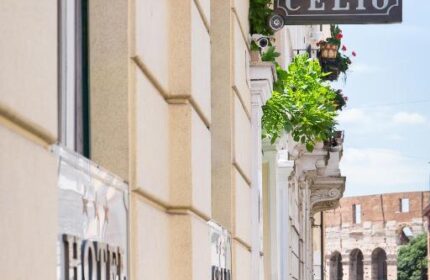 Hotel Celio, a gay-friendly hotel in Rome. Building exterior with the hotel's sign. The Colosseum is visible in the background. Travel advice.
