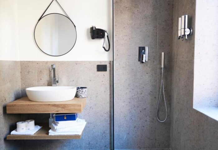Hotel Central Lodge gay-friendly hotel bathroom. Modern sink, shower, mirror, and amenities. Stylish design for gay travel.