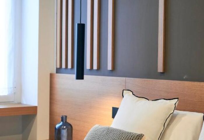 Hotel Central Lodge gay-friendly room. Modern design, wood accents, stylish lamp, and comfortable pillows. Perfect for gay travel.