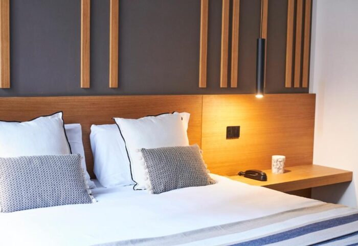 Hotel Central Lodge gay-friendly room. Modern design with wooden accents, white linens, and stylish pillows. Comfortable lodging for gay travelers.