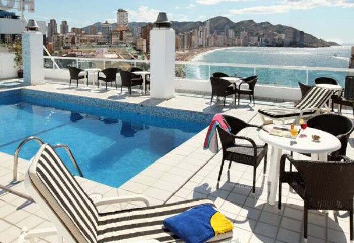 Hotel Centro Mar's rooftop pool. Gay-friendly hotel with ocean views, lounge chairs, and tables. Perfect for a relaxing vacation.