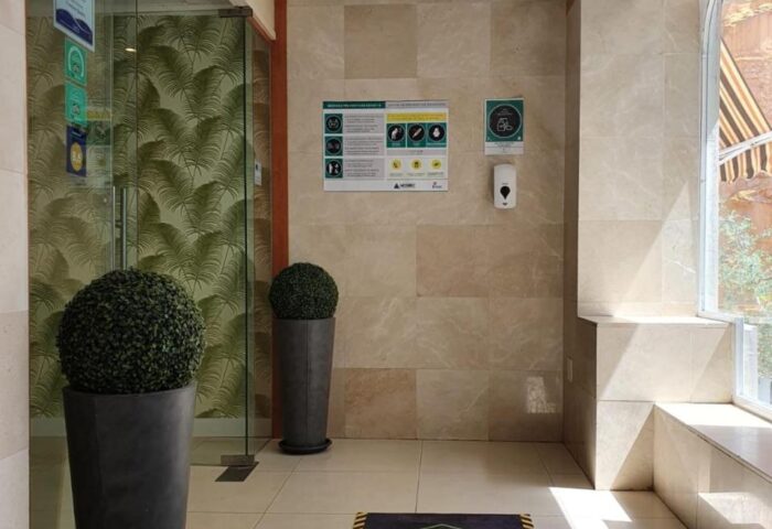 Hotel Centro Mar's interior. Zona de Limpieza mat, plants, & safety signs. Gay-friendly hotel detail for travelers.