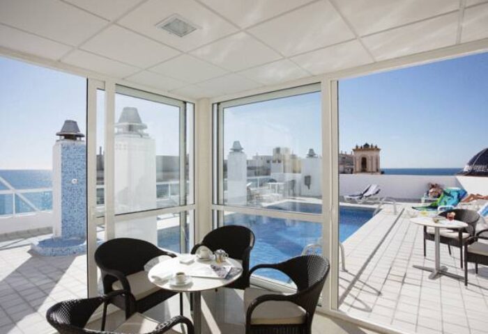 Hotel Centro Mar gay-friendly hotel room view. Rooftop pool, ocean, and sunbathers visible. Great gay travel destination.