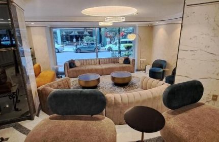 Hotel Century Reforma's gay-friendly lobby. Modern design with plush seating, round tables, and street view. A welcoming space for LGBT travelers.