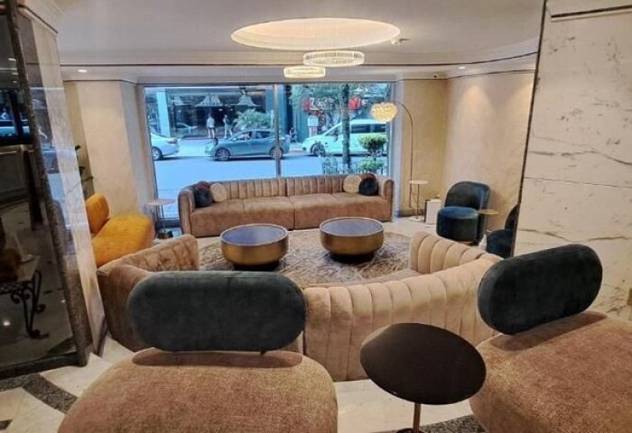 Hotel Century Reforma's gay-friendly lobby. Modern design with plush seating, round tables, and street view. A welcoming space for LGBT travelers.