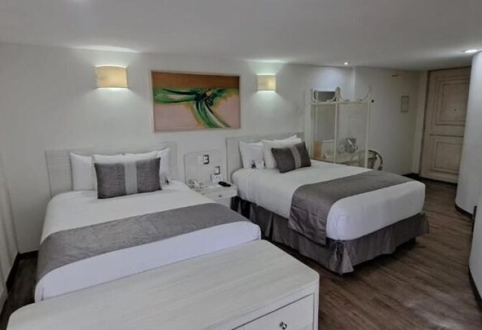 Hotel Century Reforma gay-friendly hotel: Two beds with gray accents, white walls, and modern art. A comfortable stay for gay travelers.