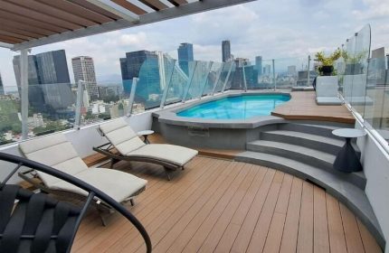Rooftop pool and lounge area at Hotel Century Reforma, a gay-friendly hotel in Mexico City. City skyline view. Perfect for gay travel.