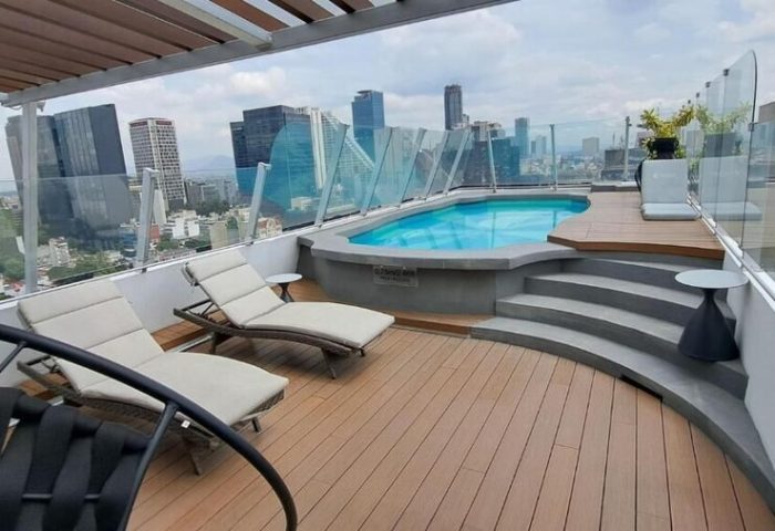 Rooftop pool and lounge area at Hotel Century Reforma, a gay-friendly hotel in Mexico City. City skyline view. Perfect for gay travel.