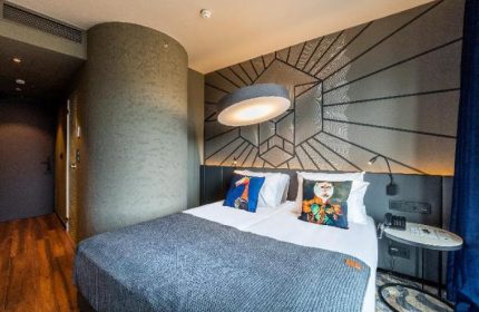 Hotel Clark Budapest gay-friendly room. Pet-friendly design with a double bed, modern lamp, and decorative pillows. Stylish, comfortable stay.