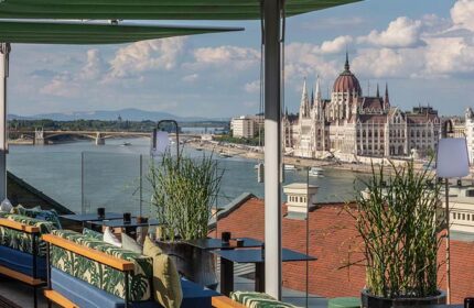 Hotel Clark Budapest rooftop bar view. Gay-friendly, pet-friendly hotel with Danube River and Hungarian Parliament Building in the background.