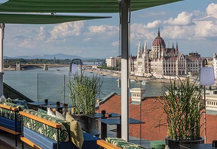 Hotel Clark Budapest rooftop bar view. Gay-friendly, pet-friendly hotel with Danube River and Hungarian Parliament Building in the background.