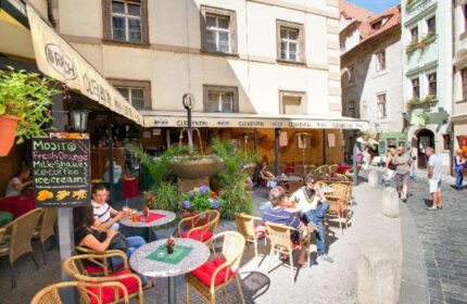 Clementin Hotel Old Town's gay-friendly, pet-friendly outdoor cafe. People enjoy drinks at tables near a fountain in Prague's Old Town.