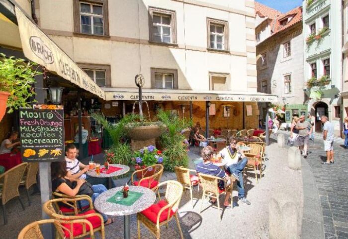 Clementin Hotel Old Town's gay-friendly, pet-friendly outdoor cafe. People enjoy drinks at tables near a fountain in Prague's Old Town.