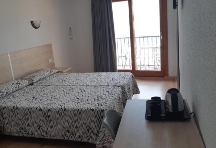 Hotel Condestable room. Gay-friendly hotel featuring twin beds, a desk with kettle, and a balcony. Comfortable stay for gay travelers.