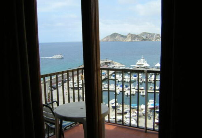 Hotel Condestable's gay-friendly view from the balcony. Boats in the harbor, sea, and distant mountains visible. Perfect for gay travel.
