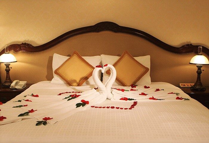 Hotel Continental Saigon, gay-friendly hotel room. Swans made of towels on the bed with rose petals. Romantic getaway for gay couples.