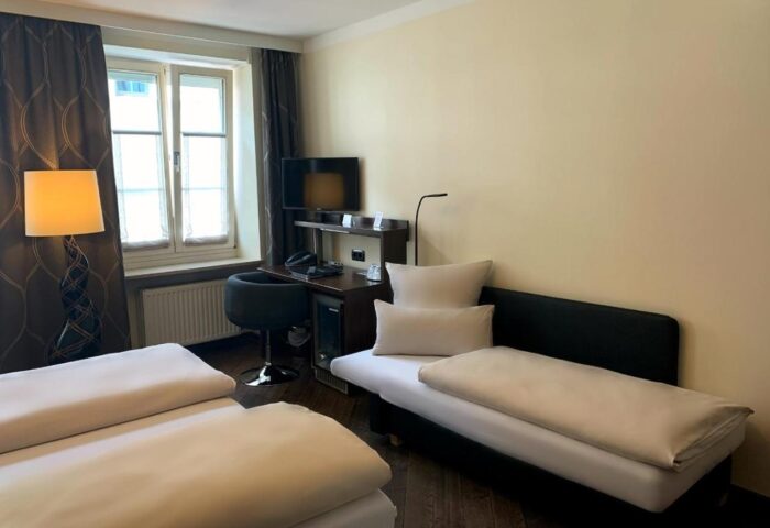 Hotel Deutsche Eiche's gay-friendly room. Twin beds, desk, TV, and sofa. Comfortable accommodations for gay travelers in Munich.