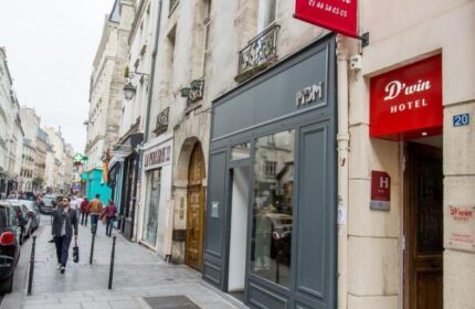 Hotel Dwin, a gay-friendly, pet-friendly hotel in Paris. The hotel's entrance is visible on a Parisian street with its red sign. A top choice for gay travel.