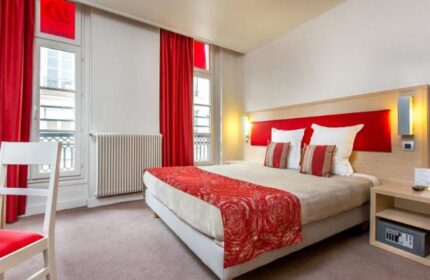 Hotel Dwin's gay-friendly, pet-friendly room. Red accents, windows, and a safe. Comfortable bed, inviting space for gay travelers.