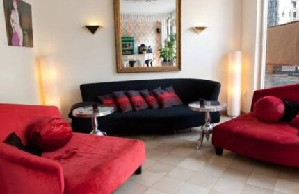 Hotel Esplanade Köln's gay-friendly lounge area. Red chaise lounges, black sofa, and stylish decor create a welcoming space for gay travelers.