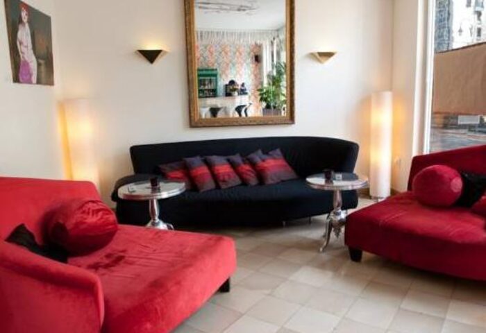 Hotel Esplanade Köln's gay-friendly lounge area. Red chaise lounges, black sofa, and stylish decor create a welcoming space for gay travelers.