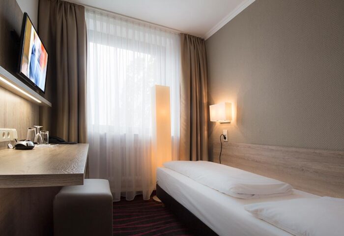 Hotel Europäischer Hof gay-friendly room. Single bed, desk, and TV. Modern decor. Comfortable stay for gay travelers. Hotel Europaischer Hof bedroom.