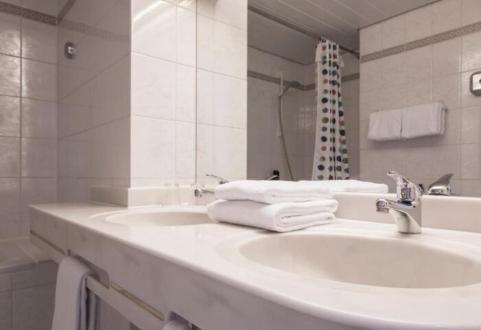 Gay-Friendly Hotel Europäischer Hof bathroom. Double sinks, white tiles, and fresh towels. A comfortable space for gay travelers.