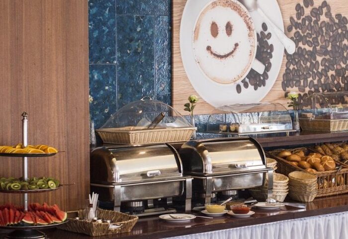 Hotel Europäischer Hof's breakfast buffet. Gay-friendly hotel offers fresh fruit, breads, and hot dishes. Cappuccino art adds a playful touch.
