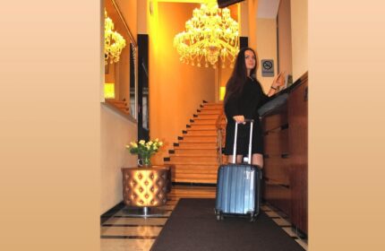 Hotel Expo Frankfurt City Centre: Woman checking in with suitcase. Gay-friendly hotel with chandelier.