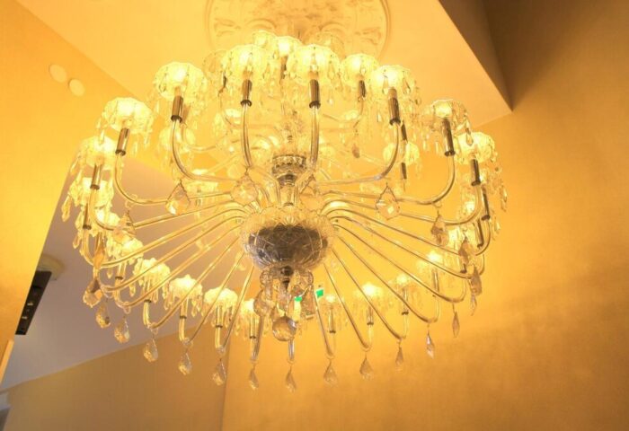 Ornate chandelier at the Gay-Friendly Hotel Expo Frankfurt City Centre. Elegant lighting fixture with crystal details. Upscale hotel ambiance.