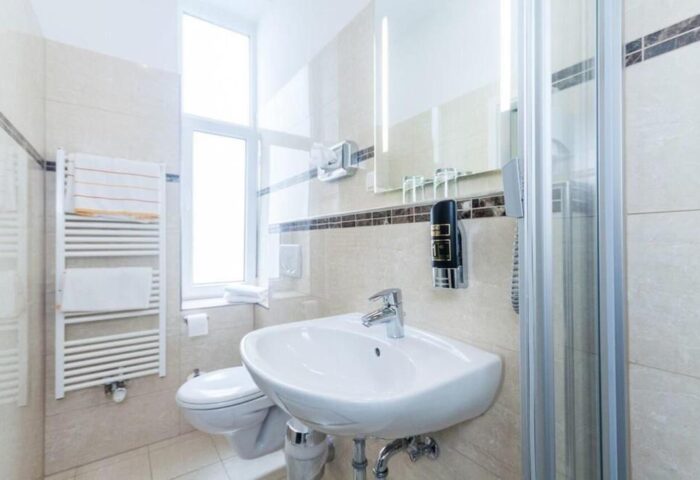 Bathroom at Gay-Friendly Hotel Expo Frankfurt City Centre. Sink, shower, and towel rack. Modern design, clean, comfortable. Perfect for gay travelers.