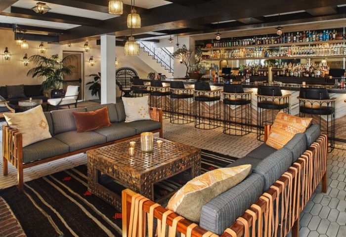 Hotel Figueroa's bar area, a gay-friendly hotel in the Unbound Collection by Hyatt. Stylish seating, bar stools, and a fully stocked bar.