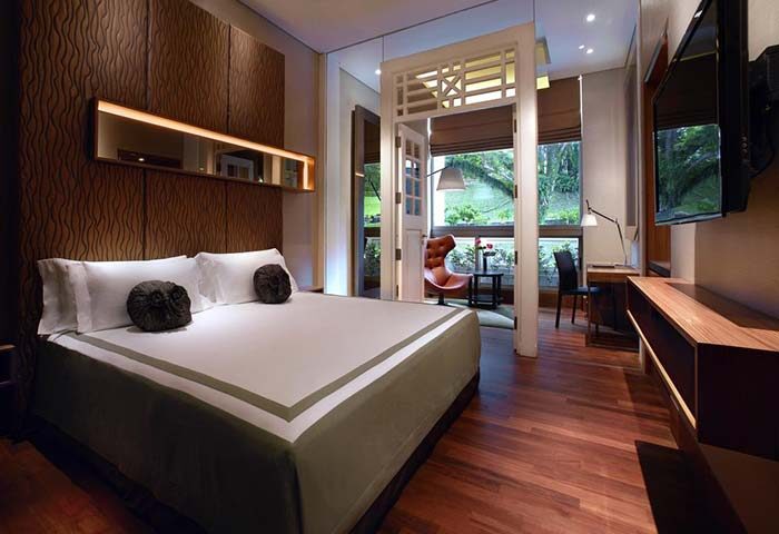 Hotel Fort Canning gay-friendly hotel room. Bedroom with king bed, desk, and balcony. A luxurious stay for gay travelers in Singapore.