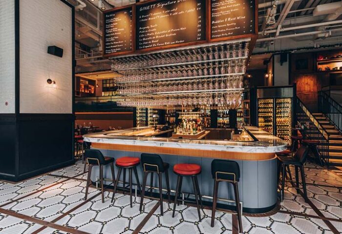 Hotel G Singapore's gay-friendly bar. Stylish interior with bar stools, wine glasses hanging above, and a menu board. A great spot for drinks.