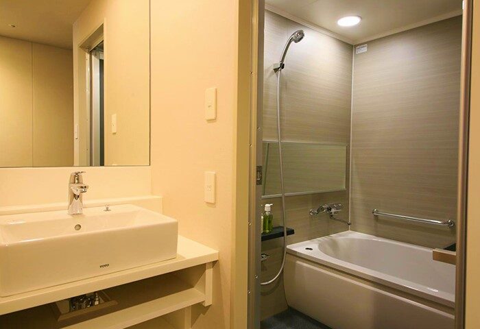 Hotel Gracery Shinjuku bathroom. Sink and mirror to the left, bathtub and shower to the right. Gay-friendly hotel with modern amenities.