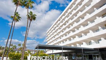 Hotel Gran Canaria Princess Adults Only entrance. Gay-friendly hotel with palm trees, white building, and blue sky. Perfect for gay men's travel.