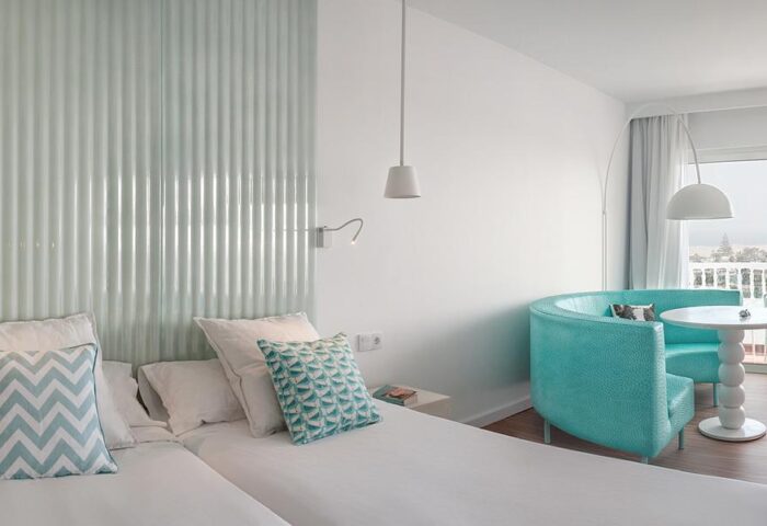 Hotel Gran Canaria Princess Adults Only room. Gay-friendly hotel at Playa del Ingles. Turquoise seating area and balcony view.