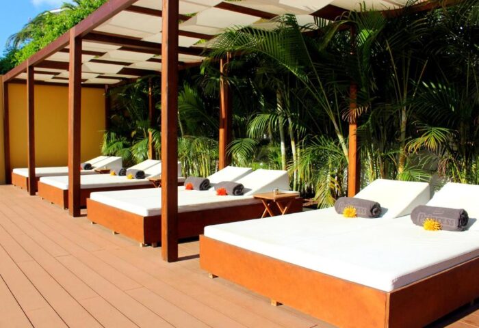 Hotel Gran Canaria Princess Adults Only sunbeds. Gay-friendly hotel with poolside loungers and tropical plants. Relaxing vacation spot.