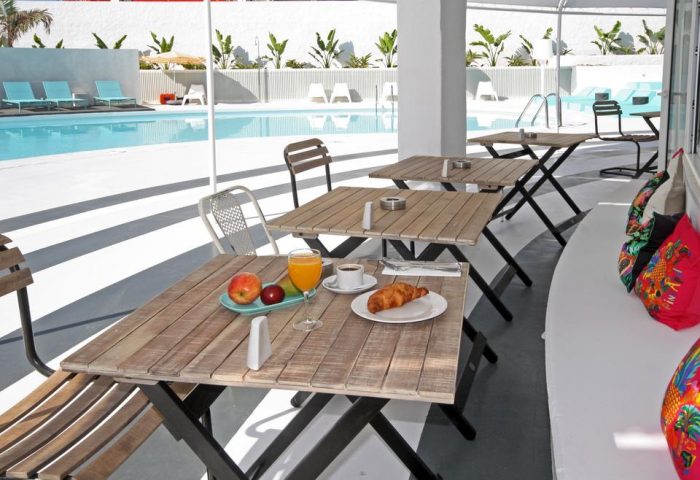 Breakfast at Gold Playa del Ingles Adults Only hotel. Gay-friendly Gran Canaria Princess hotel with pool view, tables, chairs, and pillows.