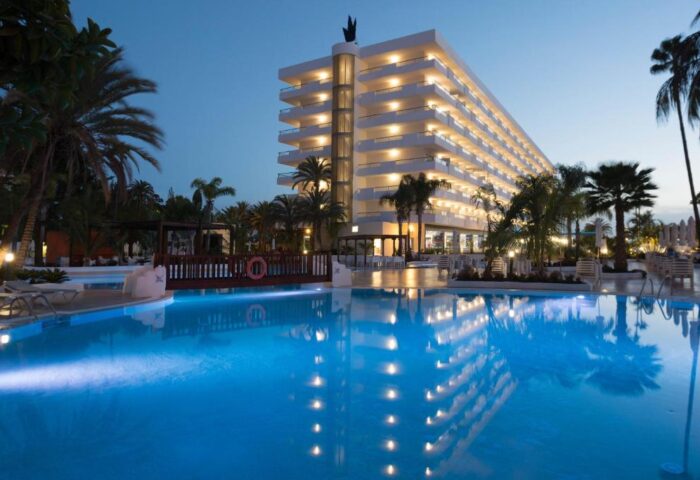 Hotel Gran Canaria Princess Adults Only: Gay-friendly hotel exterior view at dusk. Pool reflects the building's lights. Palm trees surround.