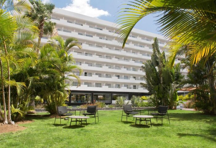 Hotel Gran Canaria Princess Adults Only, a gay-friendly hotel. Exterior view with garden, chairs, and tables for relaxing. Tropical vibes.