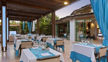 Hotel Gran Canaria Princess Adults Only gay-friendly hotel outdoor dining area. Tables set with blue accents, creating a relaxed atmosphere.
