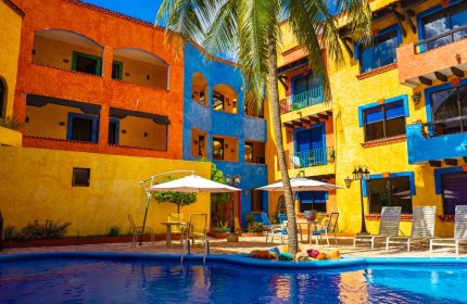 Hotel Hacienda Maria Bonita's vibrant pool area. This gay-friendly hotel features colorful architecture and a relaxing atmosphere.