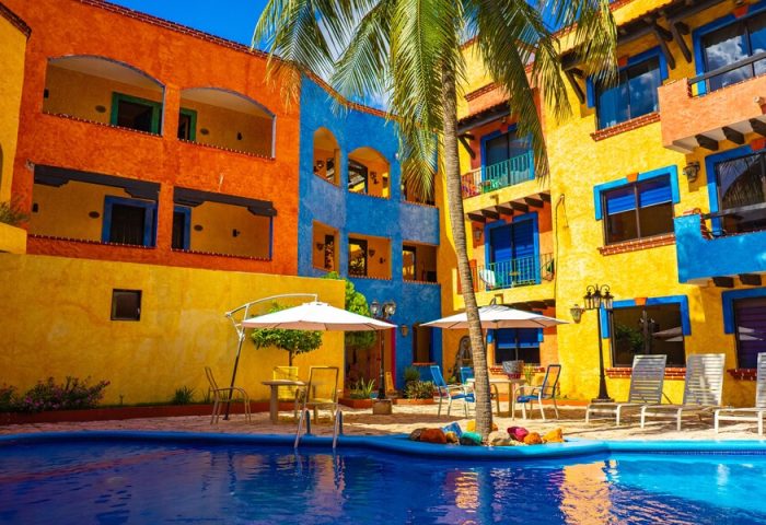 Hotel Hacienda Maria Bonita's vibrant pool area. This gay-friendly hotel features colorful architecture and a relaxing atmosphere.