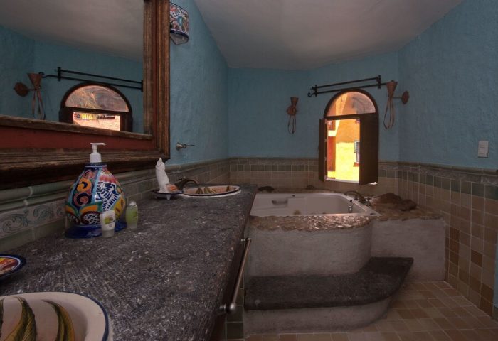 Hotel Hacienda Maria Bonita's gay-friendly bathroom. Bathtub with steps, sink, and window. A comfortable space for gay travelers.